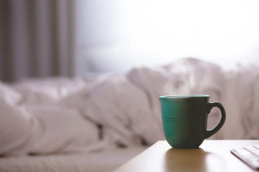 Steaming mug on a bedside table beside an unmade bed