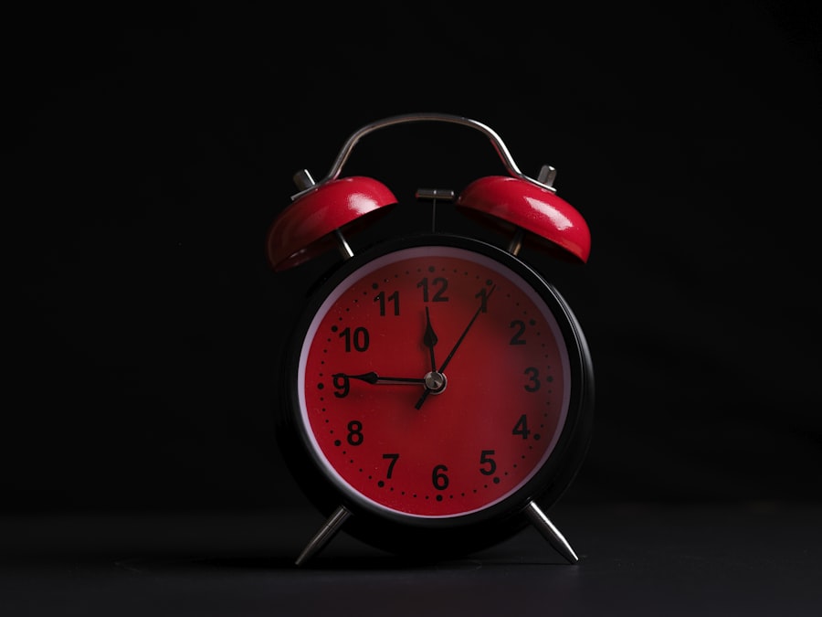 Red alarm clock on a dark background with dramatic lighting